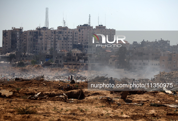 Palestinian men are searching for recyclables at a garbage dump in al-Bureij refugee camp in the central Gaza Strip, on June 22, 2024, amid...