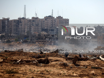 Palestinian men are searching for recyclables at a garbage dump in al-Bureij refugee camp in the central Gaza Strip, on June 22, 2024, amid...