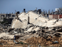 Palestinians are making their way past destroyed buildings in al-Bureij refugee camp in the central Gaza Strip, on June 22, 2024, amid the o...