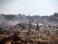 Palestinian men are searching for recyclables at a garbage dump in al-Bureij refugee camp in the central Gaza Strip, on June 22, 2024, amid...