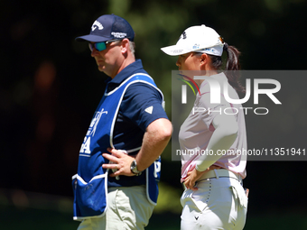 Ruoning Yin of China looks over the 2nd green with her caddie during the second round of the KPMG Women's PGA Championship at Sahalee Countr...