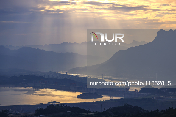 A golden sunrise is being seen over the Three Gorges Dam area in Yichang, China, on June 23, 2024, in the early morning. 