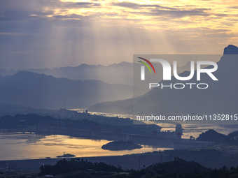 A golden sunrise is being seen over the Three Gorges Dam area in Yichang, China, on June 23, 2024, in the early morning. (