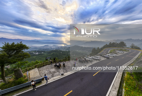 Tourists are watching the sunrise from a viewing platform on the Three Gorges Dam in Yichang, China, on June 23, 2024. 