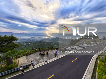 Tourists are watching the sunrise from a viewing platform on the Three Gorges Dam in Yichang, China, on June 23, 2024. (