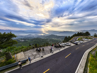 Tourists are watching the sunrise from a viewing platform on the Three Gorges Dam in Yichang, China, on June 23, 2024. (