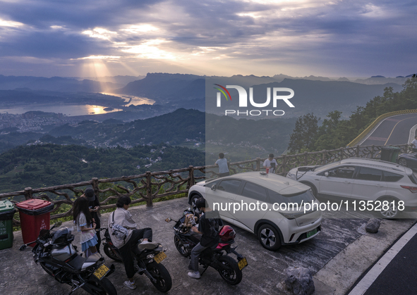 Tourists are watching the sunrise from a viewing platform on the Three Gorges Dam in Yichang, China, on June 23, 2024. 