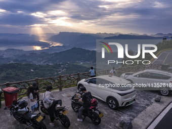 Tourists are watching the sunrise from a viewing platform on the Three Gorges Dam in Yichang, China, on June 23, 2024. (