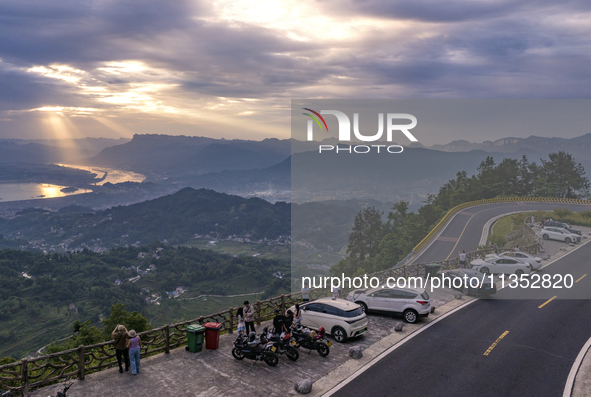 Tourists are watching the sunrise from a viewing platform on the Three Gorges Dam in Yichang, China, on June 23, 2024. 