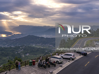 Tourists are watching the sunrise from a viewing platform on the Three Gorges Dam in Yichang, China, on June 23, 2024. (