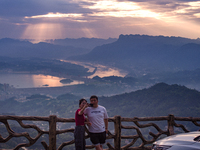 Tourists are watching the sunrise from a viewing platform on the Three Gorges Dam in Yichang, China, on June 23, 2024. (