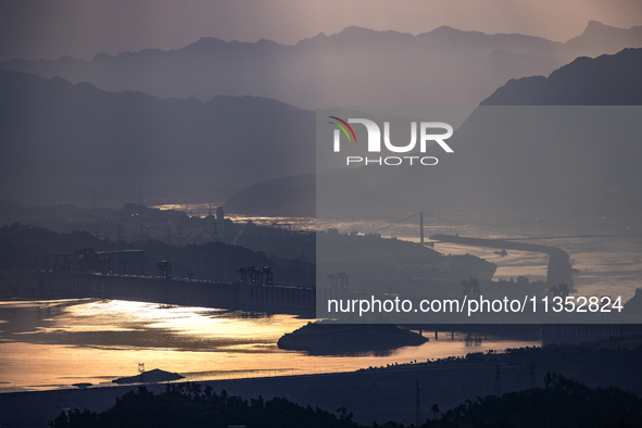 A golden sunrise is being seen over the Three Gorges Dam area in Yichang, China, on June 23, 2024, in the early morning. 