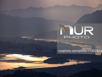 A golden sunrise is being seen over the Three Gorges Dam area in Yichang, China, on June 23, 2024, in the early morning. (