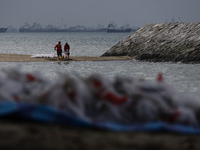 Workers are scooping up oil-stained sand at East Coast Park beach in Singapore, on June 23, 2024. Singapore authorities are continuing clean...