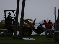 Workers are loading bags of oil-stained sand onto a wheel loader at East Coast Park beach in Singapore, on June 23, 2024. Singapore authorit...