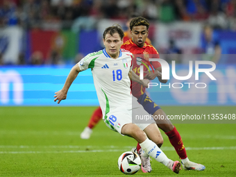 Nicolo Barella central midfield of Italy and Inter Milan and Lamine Yamal right winger of Spain and FC Barcelona compete for the ball during...