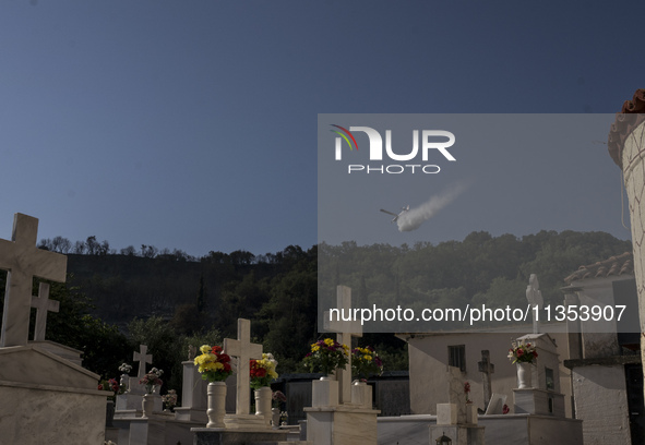 A firefighting aircraft is water bombing the wildfire that is breaking out in villages of the Ilia prefecture in ILEIA, Greece, on June 22,...