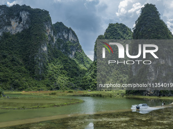 Vehicles are driving on a ''water highway'' formed by floods along a rural road in Chongzuo, China, on June 23, 2024. (