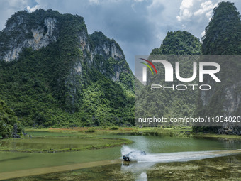 Vehicles are driving on a ''water highway'' formed by floods along a rural road in Chongzuo, China, on June 23, 2024. (