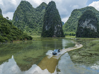 Vehicles are driving on a ''water highway'' formed by floods along a rural road in Chongzuo, China, on June 23, 2024. (