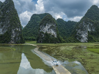 Vehicles are driving on a ''water highway'' formed by floods along a rural road in Chongzuo, China, on June 23, 2024. (