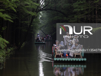 Tourists are riding a bamboo raft in the Golden Lake Water Forest Park in Huai'an, China, on June 22, 2024. (