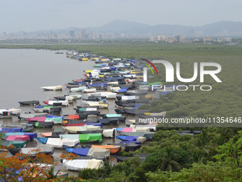 Fishing boats are being parked and covered with tarpaulin sheets in preparation for the upcoming monsoon season on the outskirts of Mumbai,...