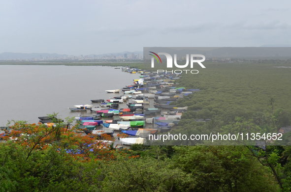 Fishing boats are being parked and covered with tarpaulin sheets in preparation for the upcoming monsoon season on the outskirts of Mumbai,...