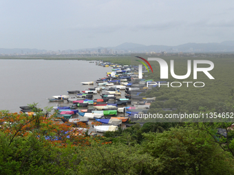 Fishing boats are being parked and covered with tarpaulin sheets in preparation for the upcoming monsoon season on the outskirts of Mumbai,...