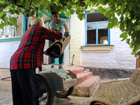 Two men are throwing away damaged belongings outside a house after a Russian missile attack in Vasylkiv, Ukraine, on June 23, 2024. On Sunda...