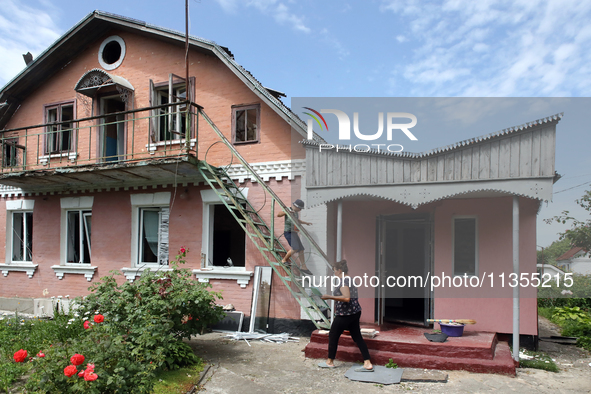 A woman and boy are standing at a house damaged by a Russian missile attack in Vasylkiv, Ukraine, on June 23, 2024. On Sunday morning, June...