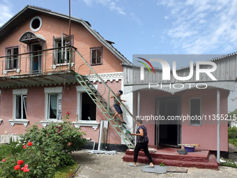 A woman and boy are standing at a house damaged by a Russian missile attack in Vasylkiv, Ukraine, on June 23, 2024. On Sunday morning, June...