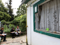 Police officers are helping a woman outside a damaged house after a Russian missile attack in Vasylkiv, Ukraine, on June 23, 2024. On Sunday...