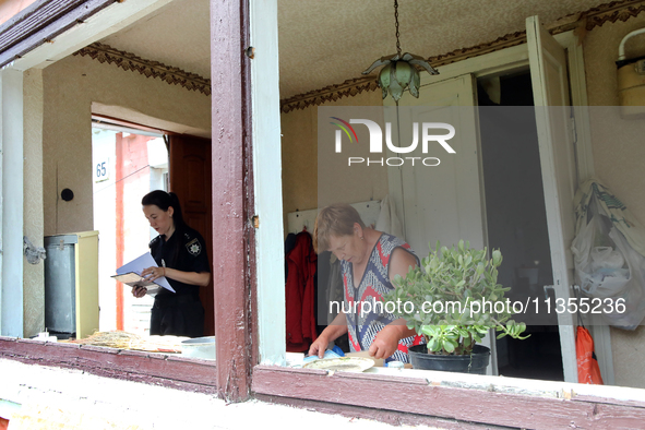 A police officer is helping a woman record the damage after a Russian missile attack in Vasylkiv, Ukraine, on June 23, 2024. On Sunday morni...