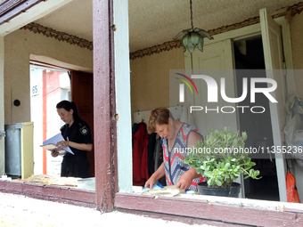 A police officer is helping a woman record the damage after a Russian missile attack in Vasylkiv, Ukraine, on June 23, 2024. On Sunday morni...