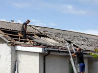 Two men are repairing the roof of a house damaged by a Russian missile attack in Vasylkiv, Ukraine, on June 23, 2024. On Sunday morning, Jun...