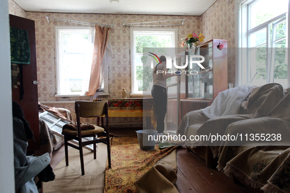 A woman is removing a knocked-out window frame in a house after a Russian missile attack in Vasylkiv, Ukraine, on June 23, 2024. On Sunday m...