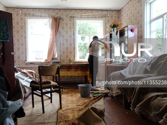 A woman is removing a knocked-out window frame in a house after a Russian missile attack in Vasylkiv, Ukraine, on June 23, 2024. On Sunday m...