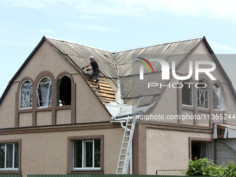 A man is repairing the roof of a house damaged by a Russian missile attack in Vasylkiv, Ukraine, on June 23, 2024. On Sunday morning, June 2...