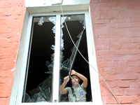 A boy is removing broken glass at a house after a Russian missile attack in Vasylkiv, Kyiv region, northern Ukraine, on June 23, 2024. On Su...