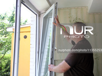 A man is examining a window in an apartment after a Russian missile attack in Vasylkiv, Ukraine, on June 23, 2024. On Sunday morning, June 2...