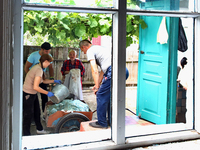 People are removing the debris as seen through a window of a house after a Russian missile attack in Vasylkiv, Ukraine, on June 23, 2024. On...