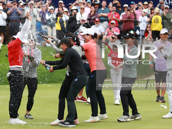 Amy Yang of Republic of Korea receives a celebratory sparkling wine shower by fellow professional golfers during the awards ceremony after w...