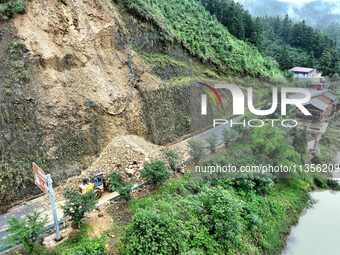 Workers are driving machinery and equipment to clear landslide soil at the site of a landslide in Datong Township on G242 National Highway i...