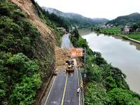 Workers are driving machinery and equipment to clear landslide soil at the site of a landslide in Datong Township on G242 National Highway i...