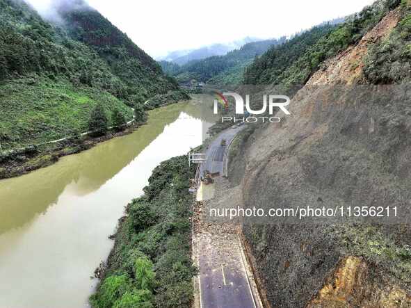 Workers are driving machinery and equipment to clear landslide soil at the site of a landslide in Datong Township on G242 National Highway i...