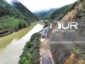 Workers are driving machinery and equipment to clear landslide soil at the site of a landslide in Datong Township on G242 National Highway i...