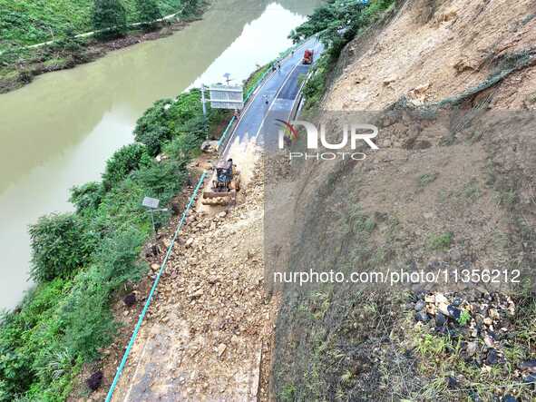 Workers are driving machinery and equipment to clear landslide soil at the site of a landslide in Datong Township on G242 National Highway i...