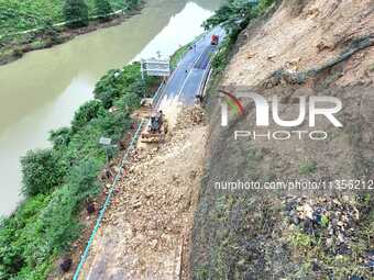 Workers are driving machinery and equipment to clear landslide soil at the site of a landslide in Datong Township on G242 National Highway i...