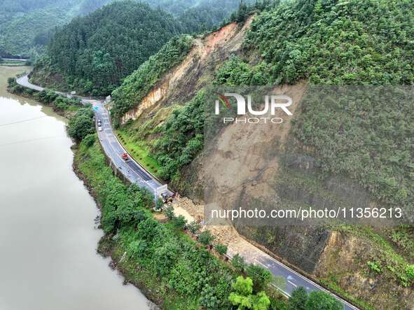 Workers are driving machinery and equipment to clear landslide soil at the site of a landslide in Datong Township on G242 National Highway i...